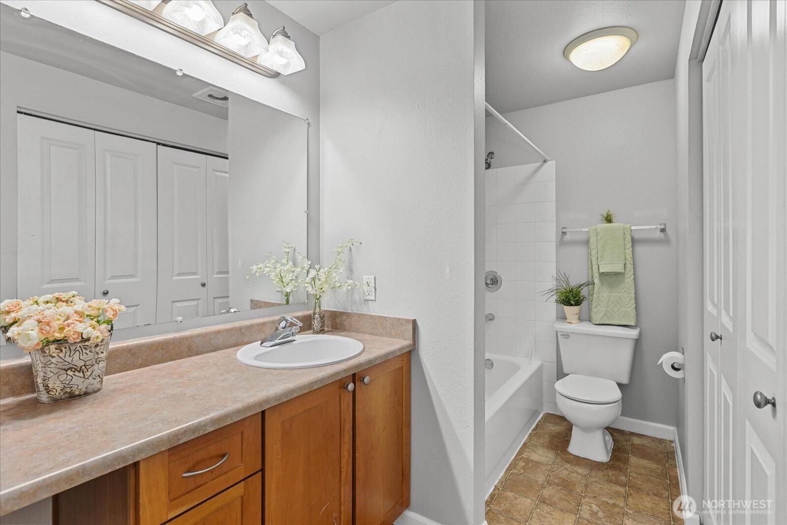 10831 Northeast 147th Lane, Unit R202 Bothell, WA 98011 - Photo 15 of 30 a bathroom with a granite countertop sink a toilet and a mirror