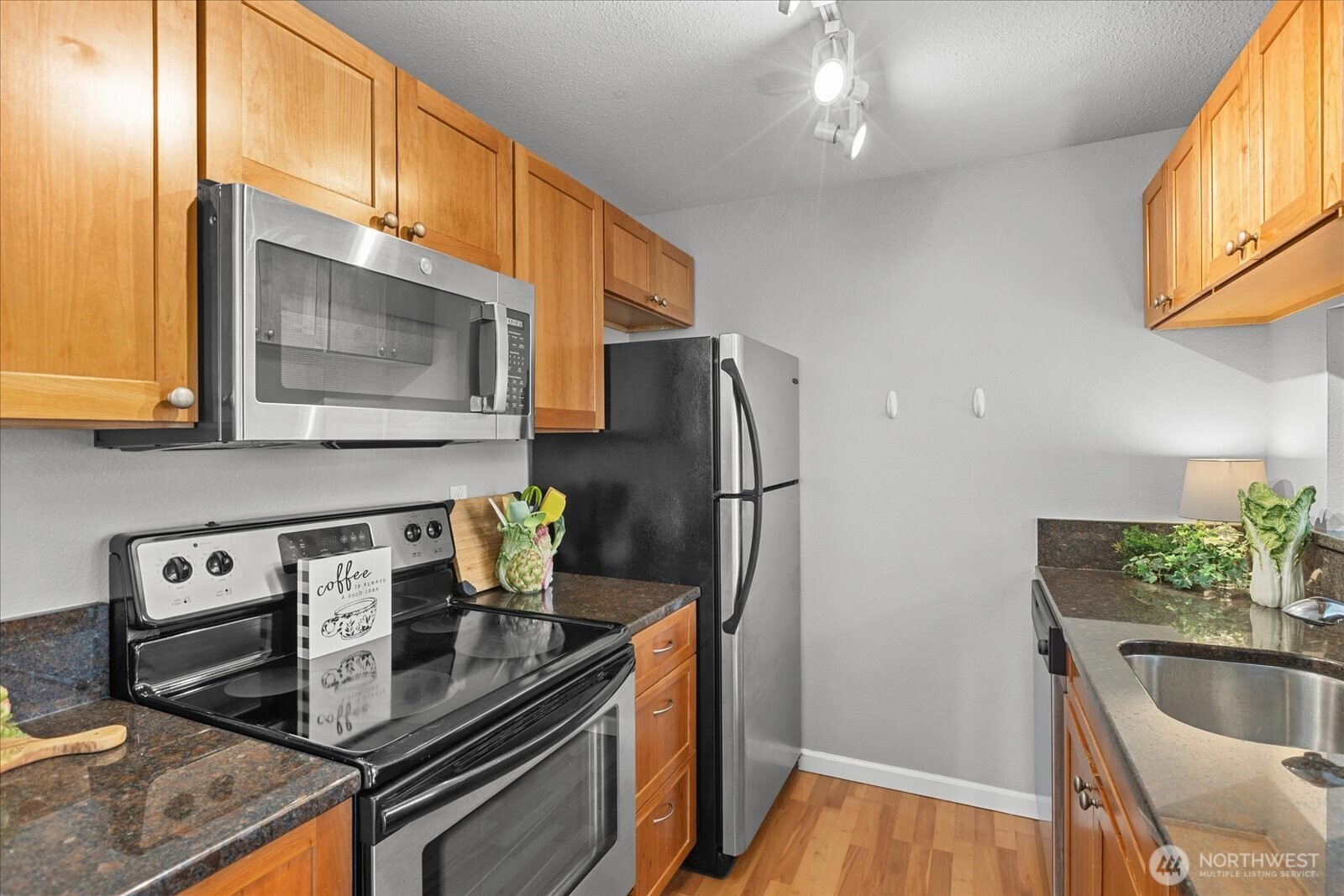 10831 Northeast 147th Lane, Unit R202 Bothell, WA 98011 - Photo 9 of 30 a kitchen with stainless steel appliances granite countertop a refrigerator a stove and a wooden floor