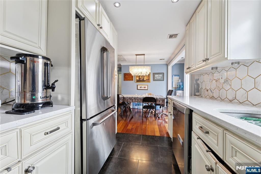 74 Spring Avenue Bergenfield, NJ 07621 - Photo 13 of 39 a kitchen with stainless steel appliances granite countertop a refrigerator and a stove