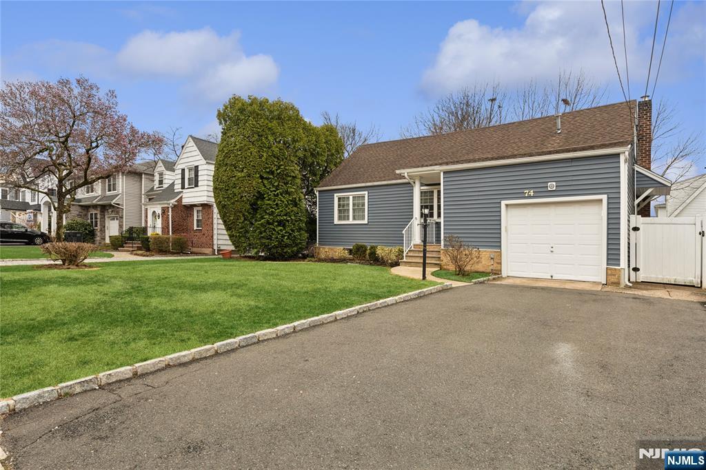 74 Spring Avenue Bergenfield, NJ 07621 - Photo 2 of 39 a view of a house with a yard and garage
