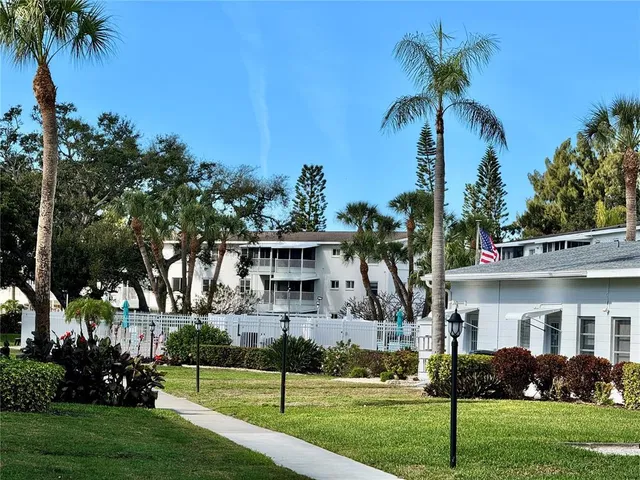 a front view of a house with a garden and trees