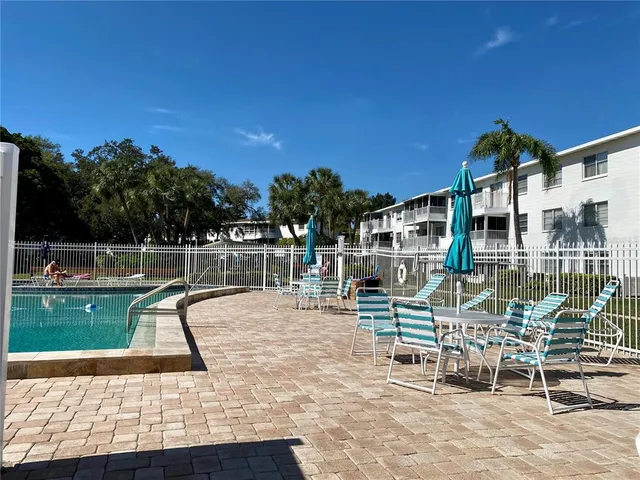 a view of a swimming pool with outdoor seating and plants