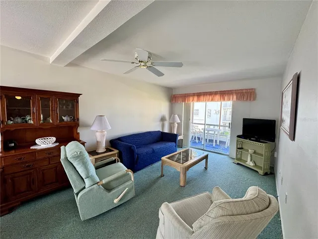 a living room with furniture a flat screen tv and a window