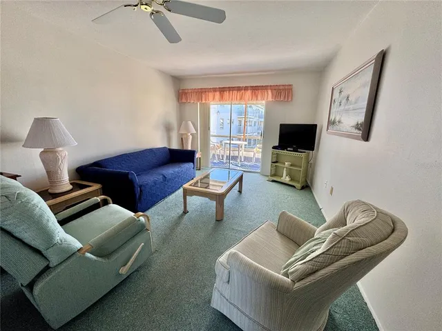 a living room with furniture a flat screen tv and a large window