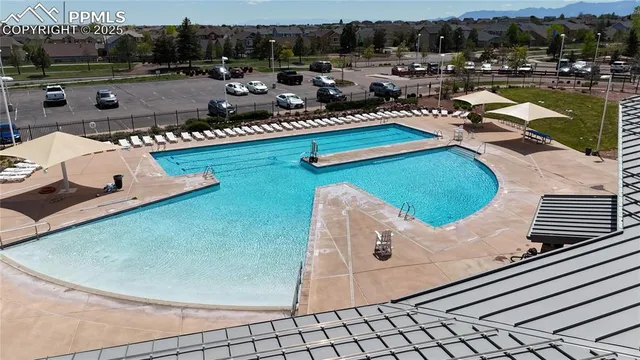 a view of a swimming pool with lawn chairs and a patio