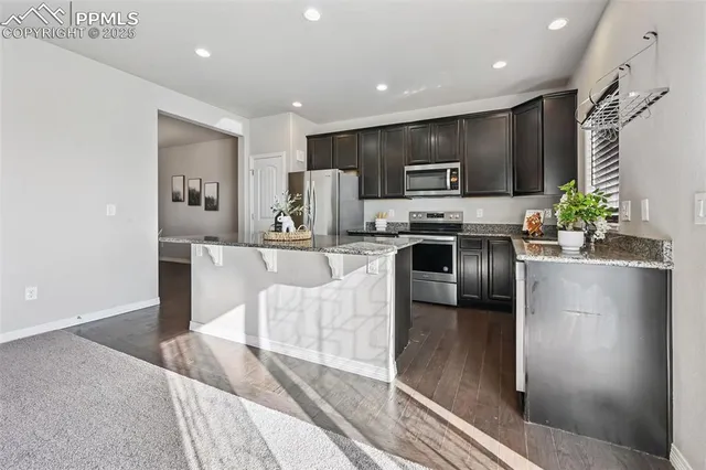 a kitchen with kitchen island stainless steel appliances a sink stove and refrigerator