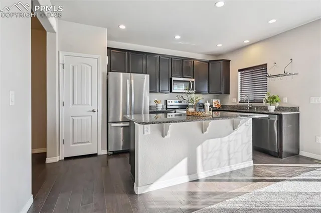 a kitchen with stainless steel appliances granite countertop a refrigerator sink and cabinets
