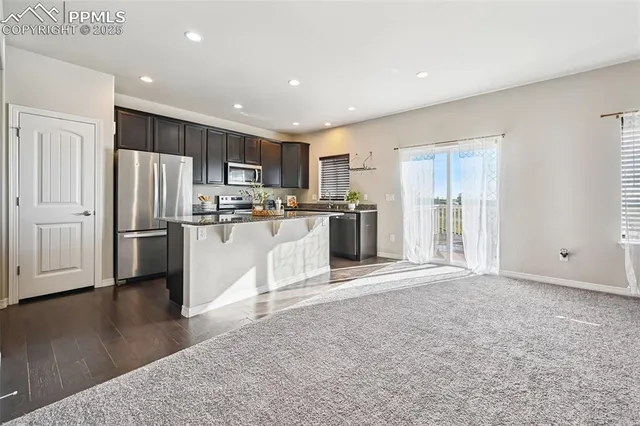 a kitchen with stainless steel appliances granite countertop a refrigerator and a stove top oven