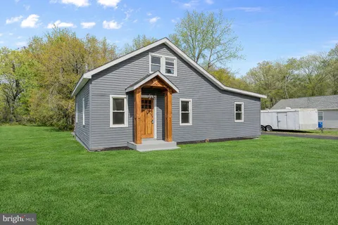 a front view of a house with a yard and trees