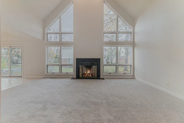 an empty room with windows and fireplace