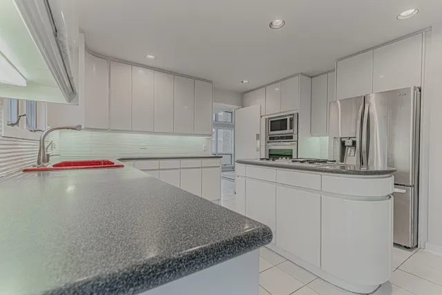 a kitchen with a sink a microwave and cabinets