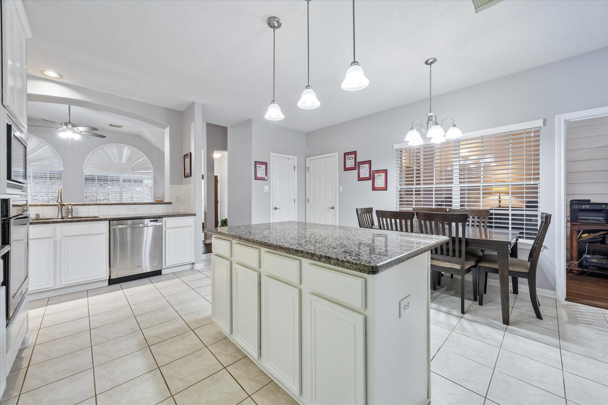 12423 Rutgers Park Court Houston, TX 77058 - Photo 14 of 29 a kitchen with stainless steel appliances granite countertop a stove a sink a oven a dining table and chairs cabinets