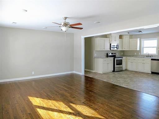 397 Lone Star Road Lawrenceburg, TN 38464 - Photo 4 of 13 a large kitchen with a wooden floor and stainless steel appliances