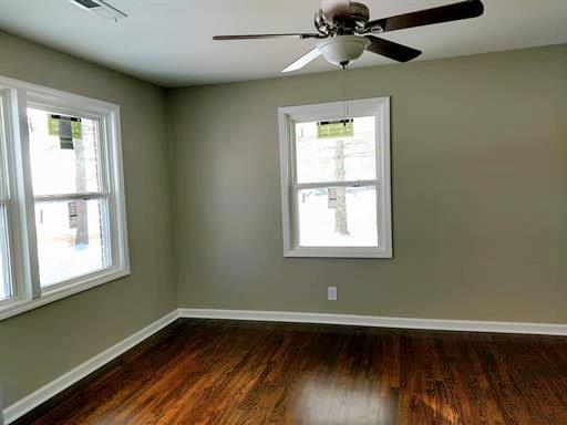 397 Lone Star Road Lawrenceburg, TN 38464 - Photo 10 of 13 an empty room with wooden floor chandelier fan and windows
