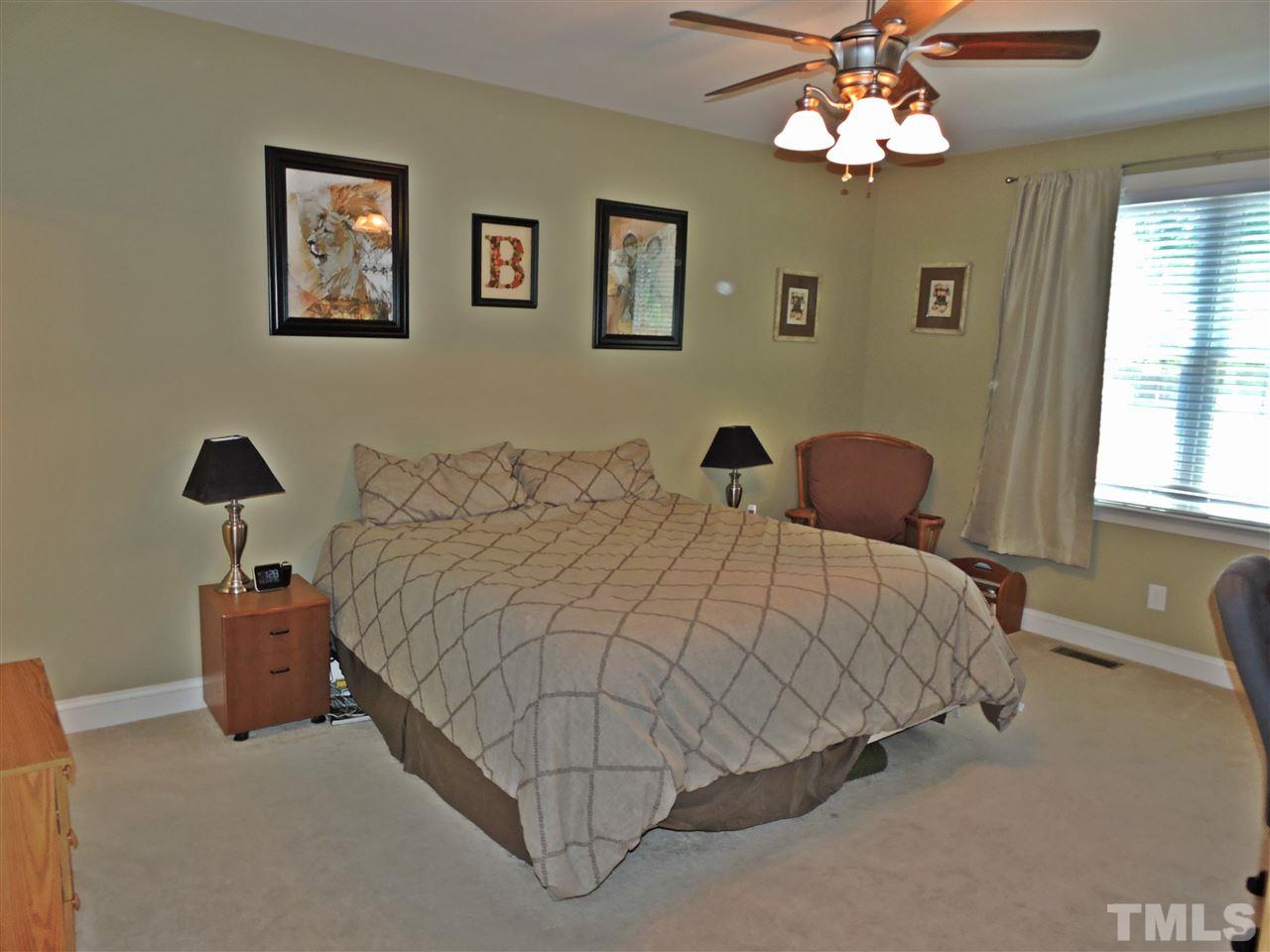 174 Weaver Ridge Road Rougemont, NC 27572 - Photo 16 of 25 a bedroom with a bed and a chandelier