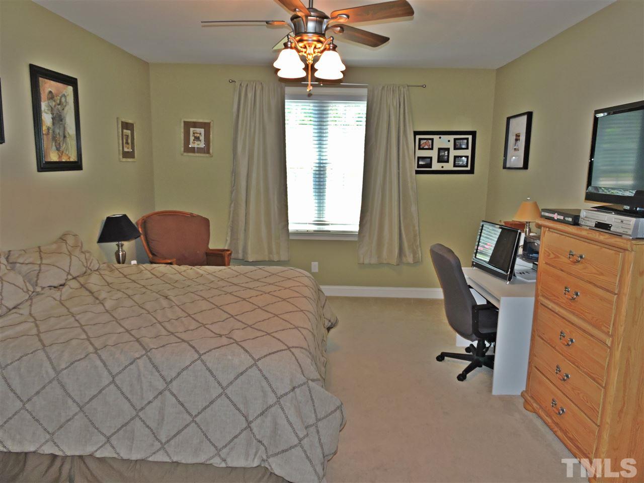174 Weaver Ridge Road Rougemont, NC 27572 - Photo 18 of 25 a bedroom with a large bed and a chandelier