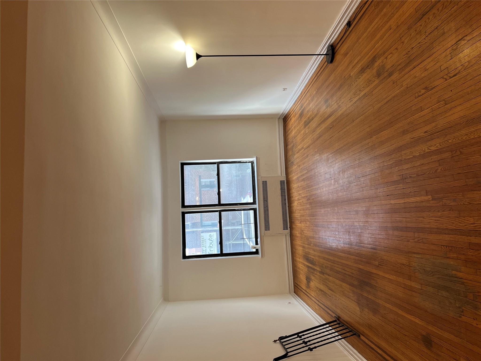 35-35 75th Street, Unit 127 Queens, NY 11372 - Photo 16 of 50 Empty room featuring radiator, wood-type flooring, and ornamental molding