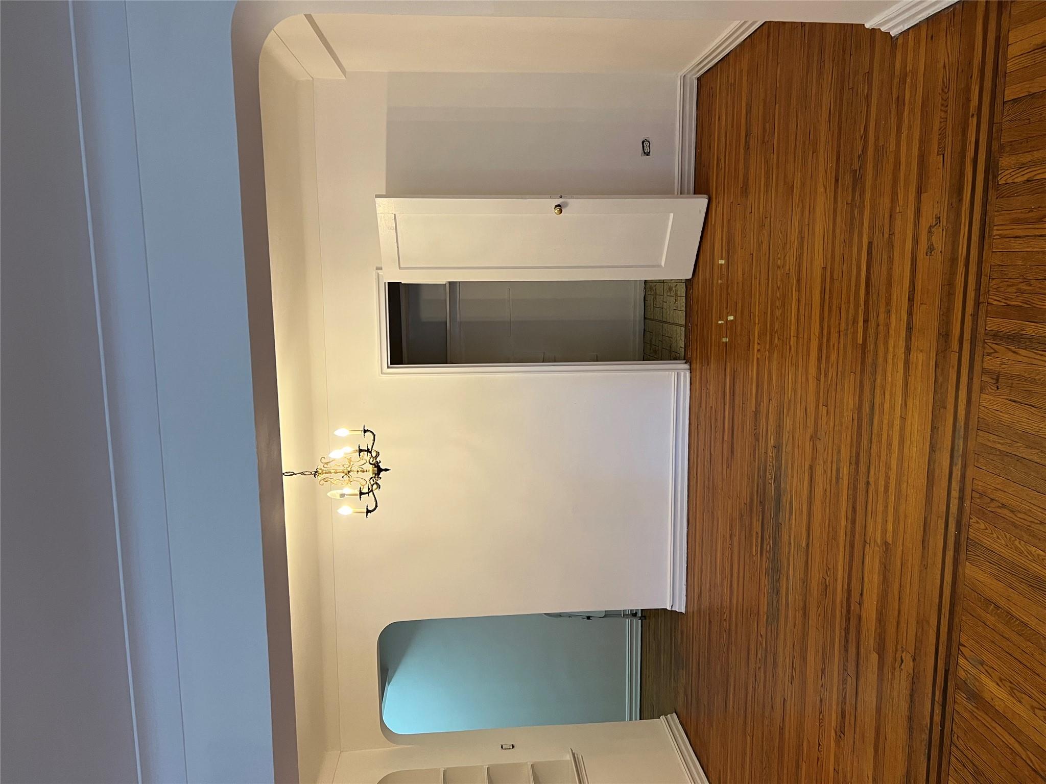 35-35 75th Street, Unit 127 Queens, NY 11372 - Photo 18 of 50 Spare room with dark hardwood / wood-style flooring and a chandelier