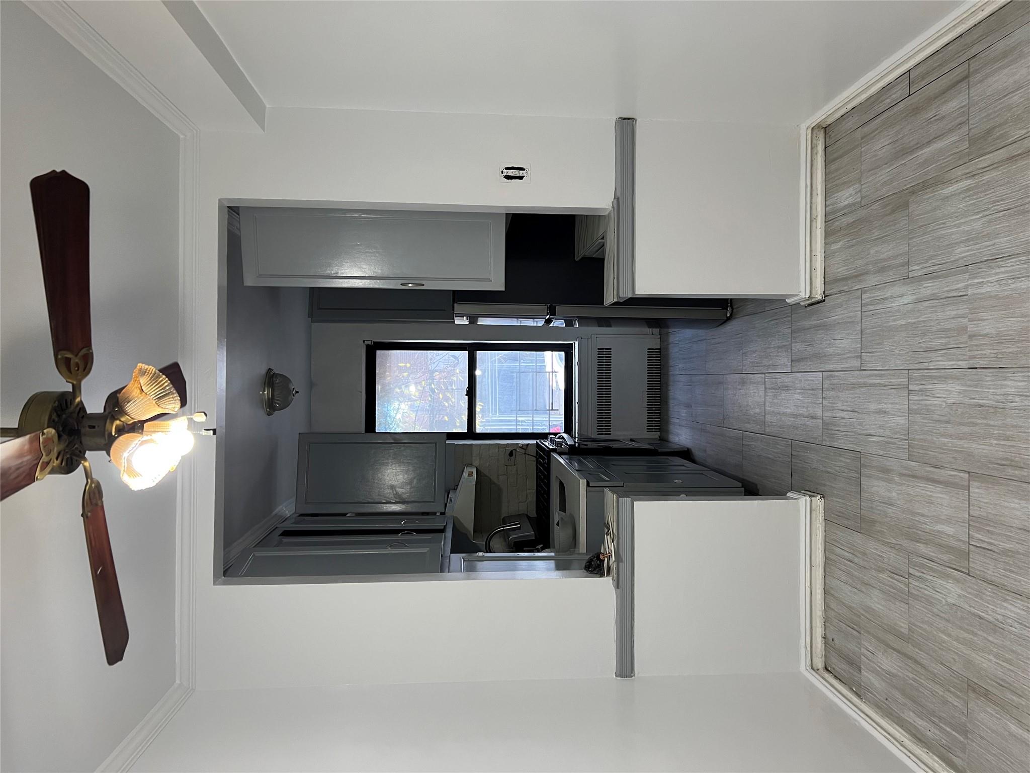 35-35 75th Street, Unit 127 Queens, NY 11372 - Photo 21 of 50 Kitchen with ornamental molding, light hardwood / wood-style flooring, radiator, and gray cabinetry