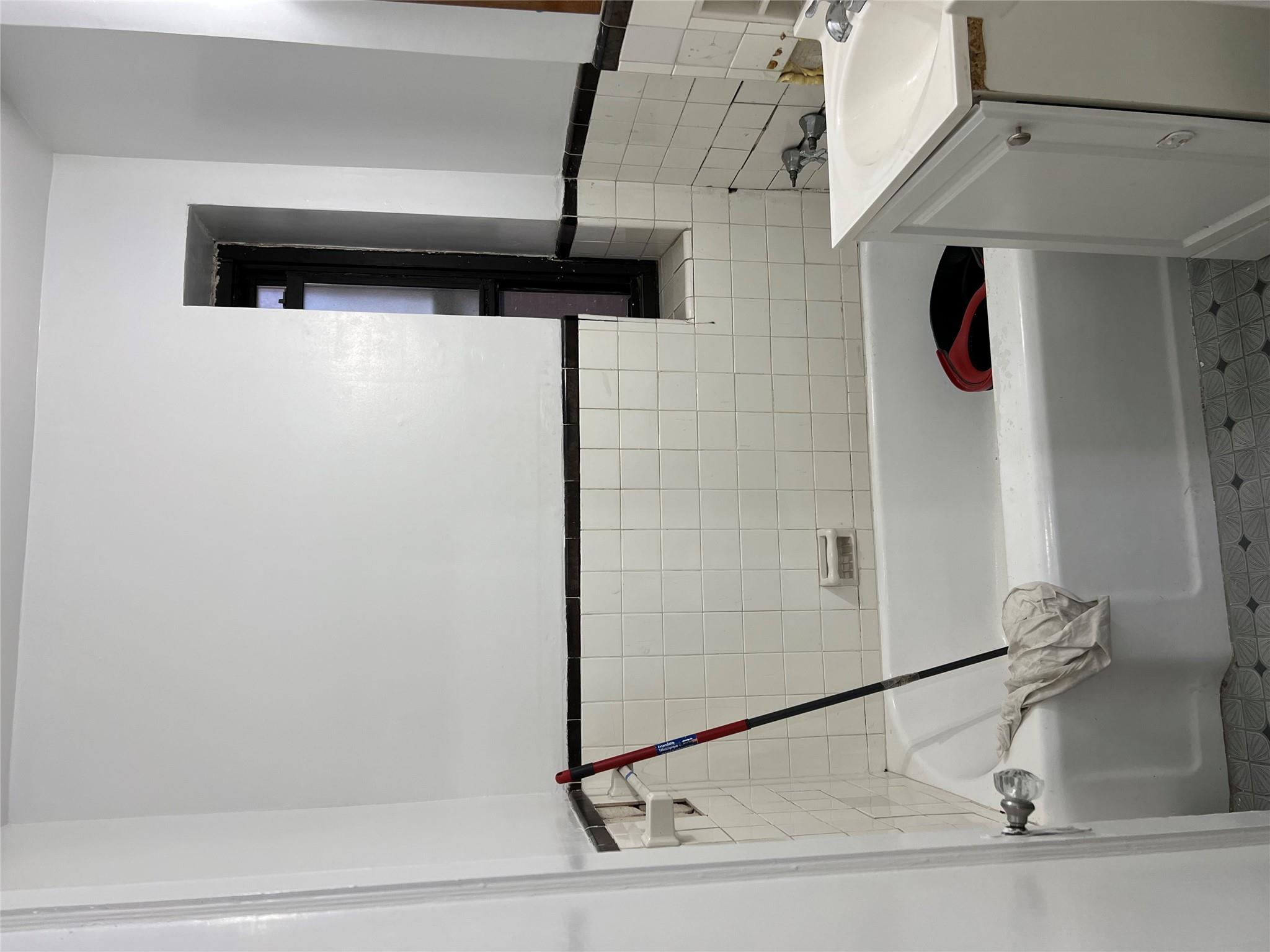 35-35 75th Street, Unit 127 Queens, NY 11372 - Photo 25 of 50 Bathroom featuring a bathtub, vanity, and tile walls