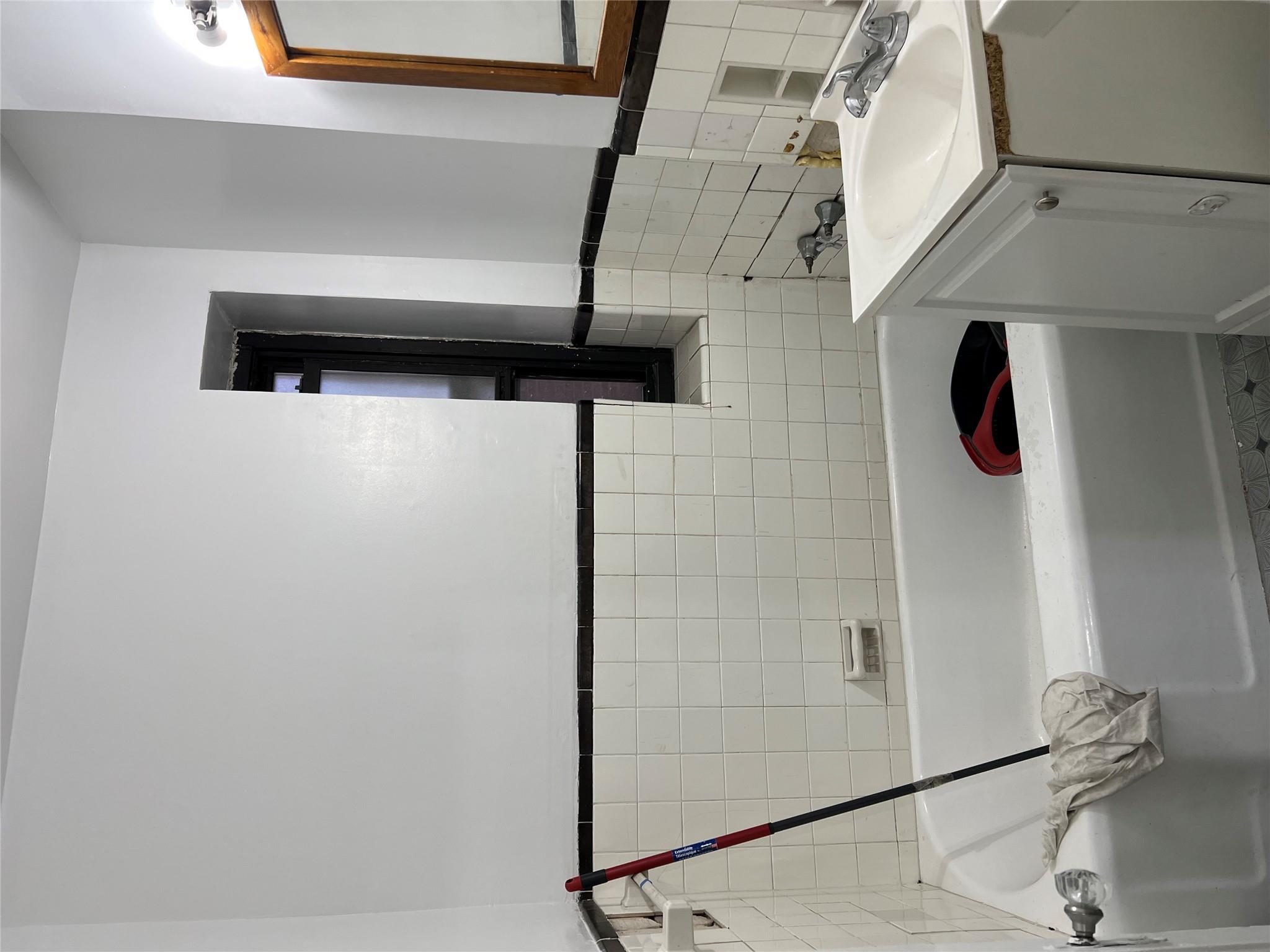 35-35 75th Street, Unit 127 Queens, NY 11372 - Photo 26 of 50 Bathroom with a washtub, vanity, and tile walls