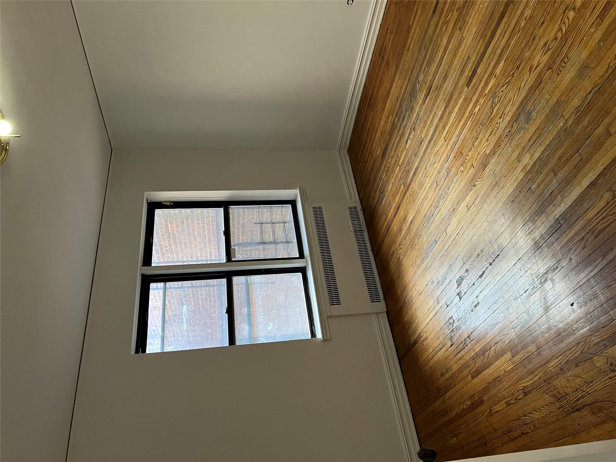 35-35 75th Street, Unit 127 Queens, NY 11372 - Photo 28 of 50 Empty room with radiator heating unit and wood-type flooring