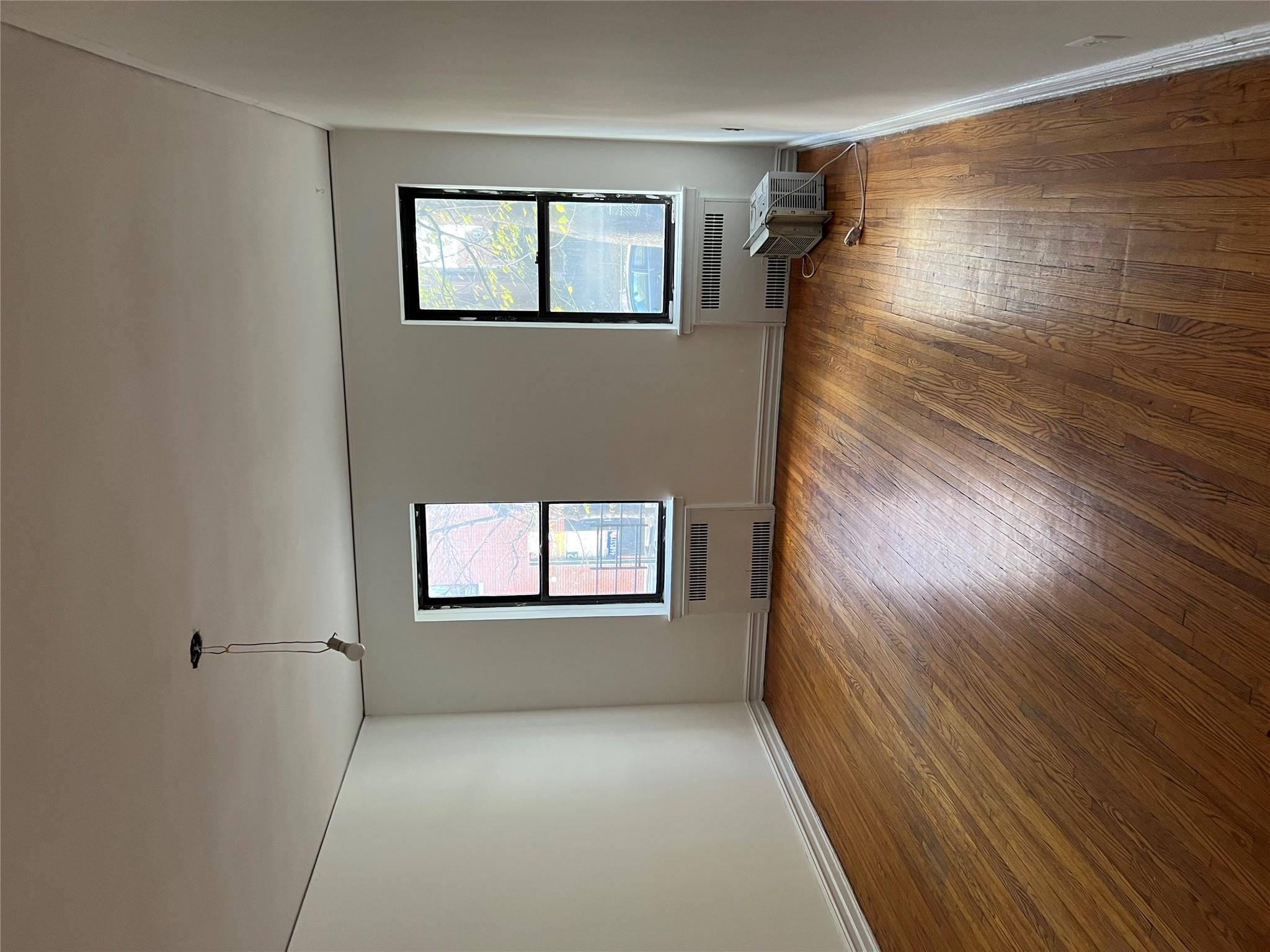 35-35 75th Street, Unit 127 Queens, NY 11372 - Photo 29 of 50 Spare room with radiator and dark hardwood / wood-style flooring