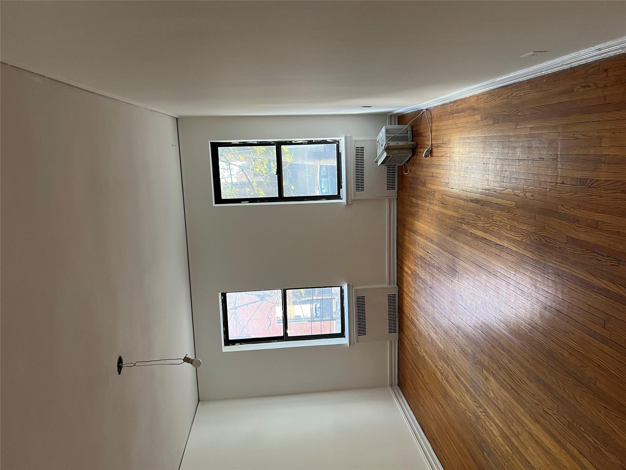35-35 75th Street, Unit 127 Queens, NY 11372 - Photo 30 of 50 Spare room with radiator, dark hardwood / wood-style flooring, and a healthy amount of sunlight