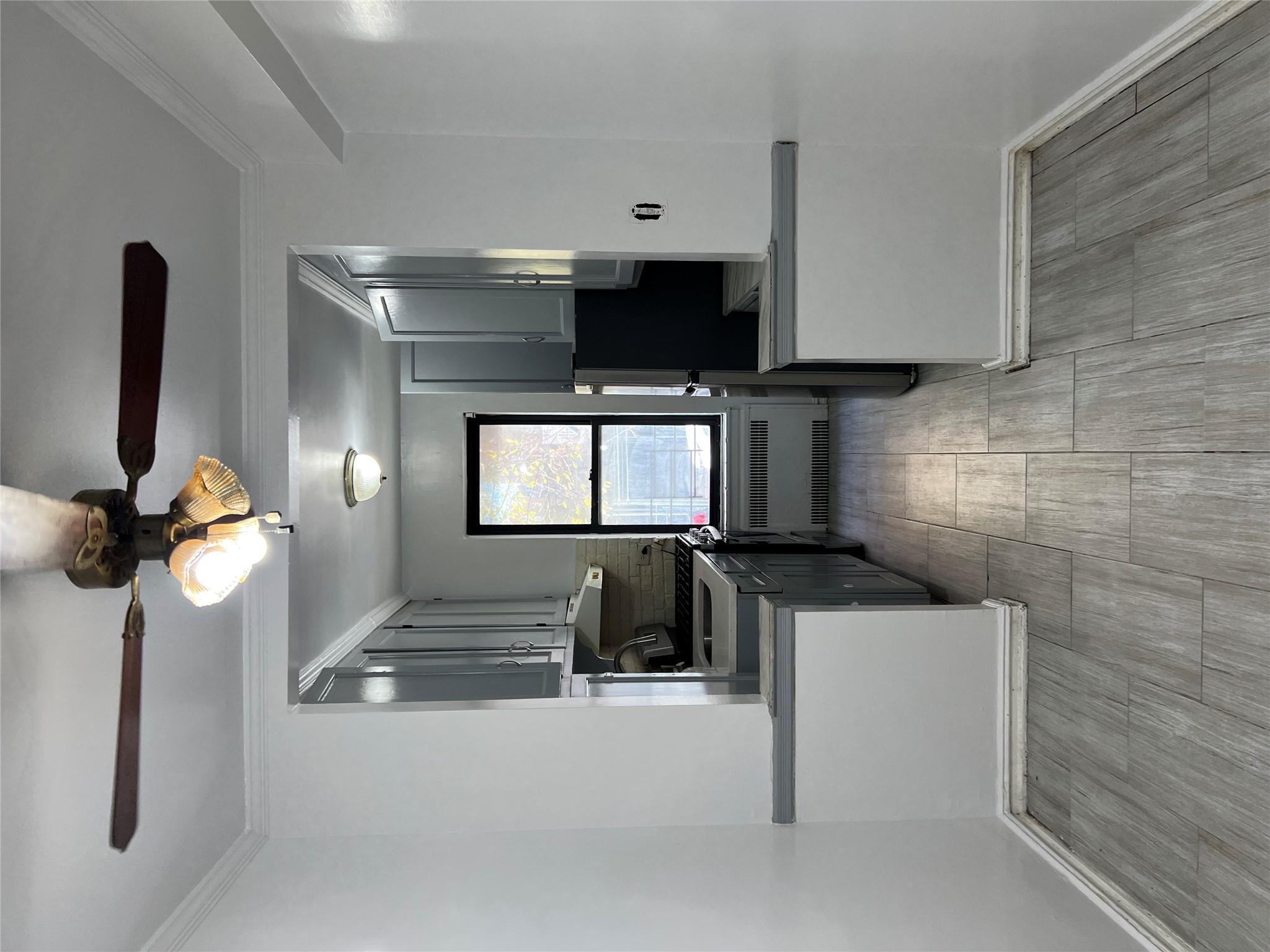 35-35 75th Street, Unit 127 Queens, NY 11372 - Photo 34 of 50 Kitchen with backsplash, gray cabinets, and radiator