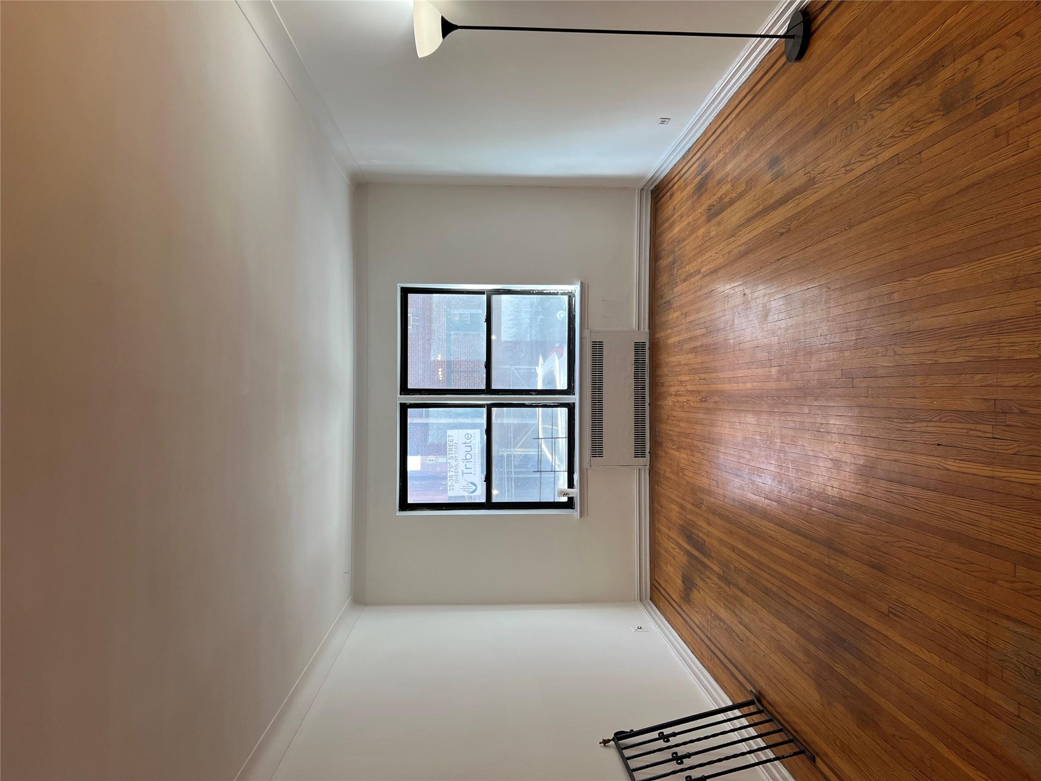 35-35 75th Street, Unit 127 Queens, NY 11372 - Photo 35 of 50 Empty room featuring dark hardwood / wood-style flooring, radiator, and ornamental molding