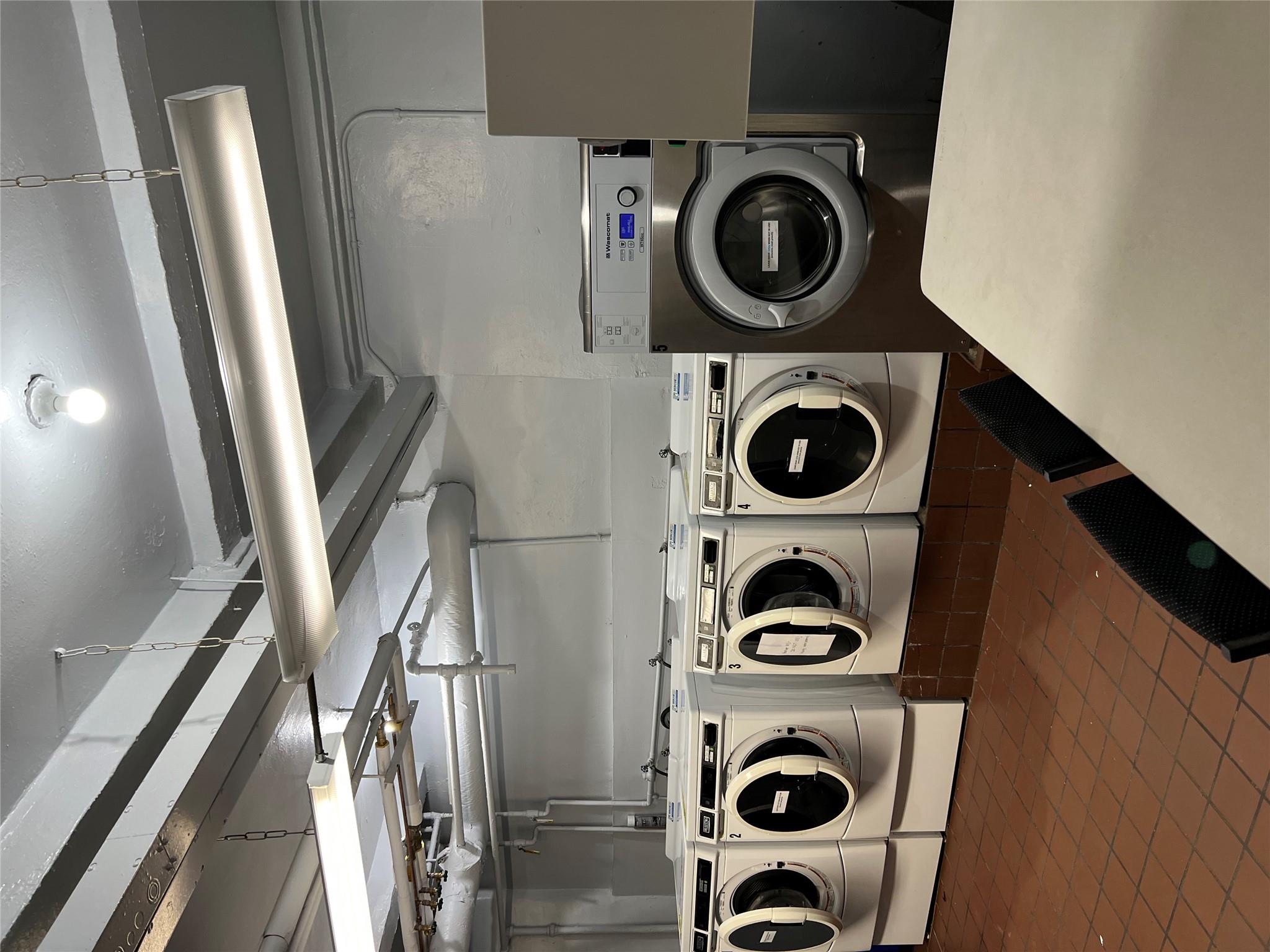 35-35 75th Street, Unit 127 Queens, NY 11372 - Photo 41 of 50 Laundry area with dark tile patterned flooring and washer and dryer