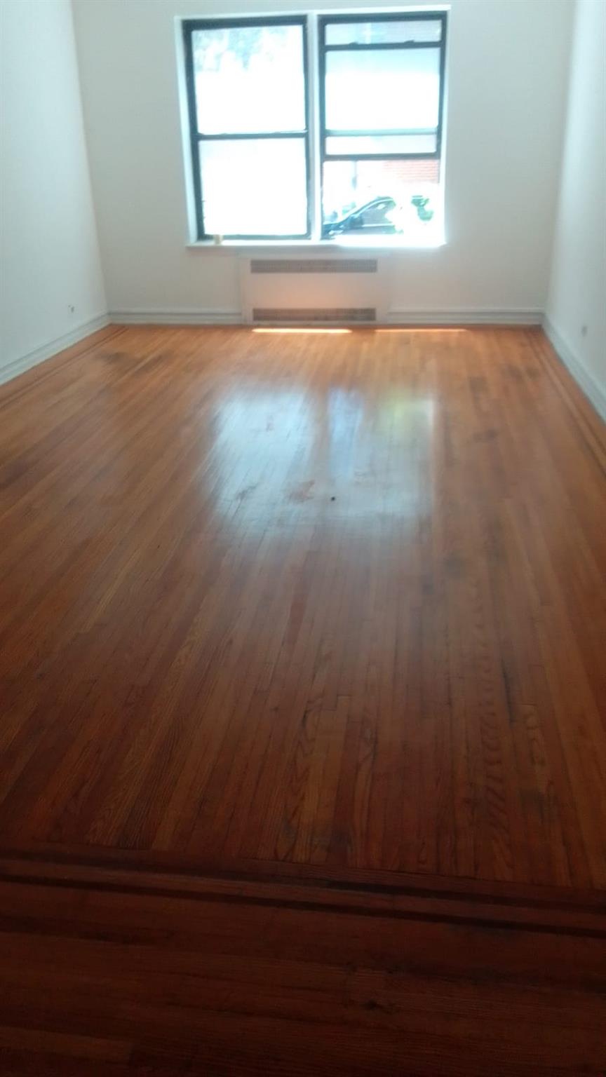 35-35 75th Street, Unit 127 Queens, NY 11372 - Photo 48 of 50 Unfurnished room with plenty of natural light and wood finished floors