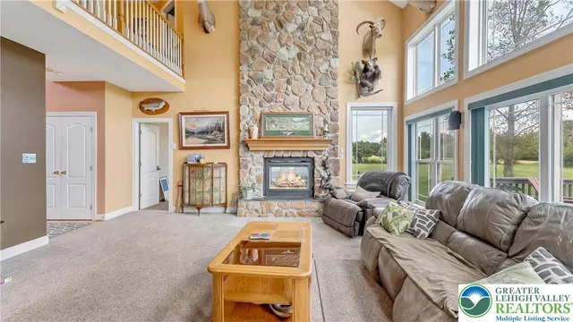 a dining room with furniture a chandelier and large window