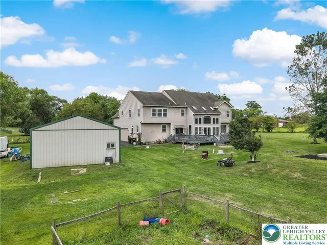 an aerial view of a house with a garden and lake view