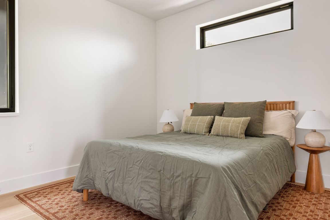 505 Philco Drive, Unit 3 Austin, TX 78745 - Photo 32 of 36 a bedroom with a bed and wooden floor