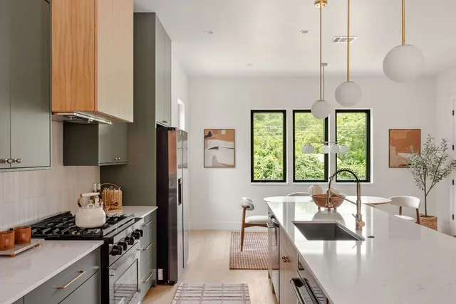 a kitchen with stainless steel appliances granite countertop a stove a sink and a microwave