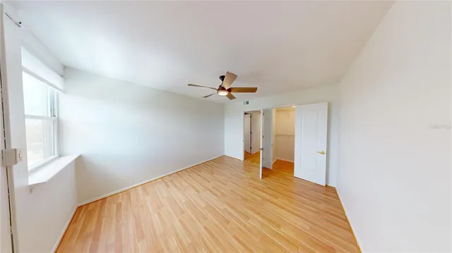 a view of a room with a ceiling fan and wooden floor