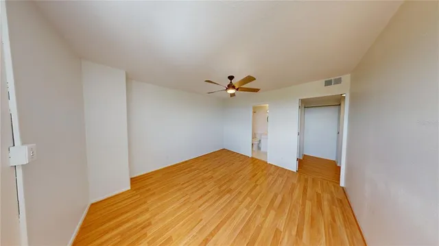 a view of a big room with wooden floor and fan