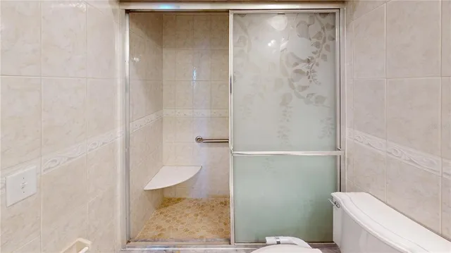 a view of an empty room with wooden floor and a ceiling fan