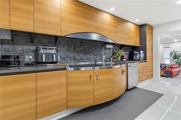 a kitchen with stainless steel appliances kitchen island granite countertop a sink and cabinets