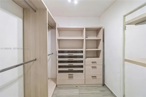 a view of walk in closet with empty racks