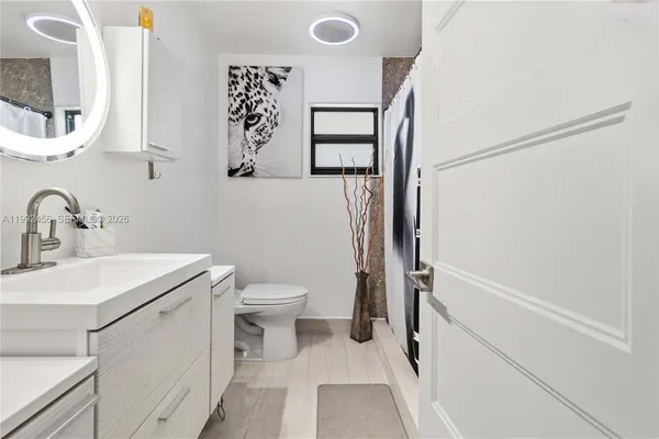 a bathroom with a sink a toilet and shower