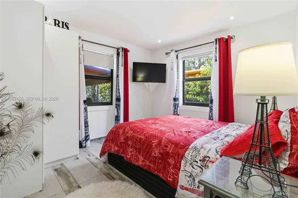 a bedroom with a bed and a flat screen tv