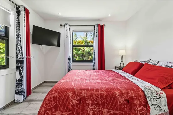 a bedroom with a large bed and a flat screen tv