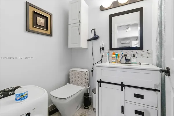 a bathroom with a toilet sink vanity and mirror