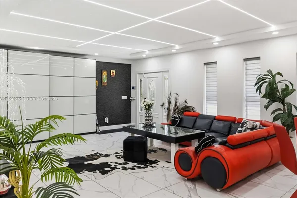 a living room with patio furniture and a potted plant