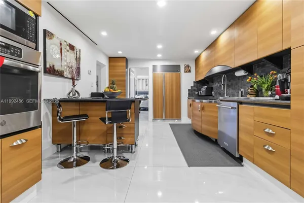 a kitchen with stainless steel appliances granite countertop a sink a stove and a refrigerator