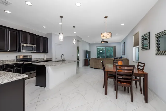 a kitchen with granite countertop a stove a sink and a microwave