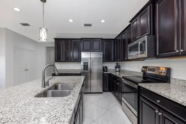 a kitchen with granite countertop a stove sink and cabinets
