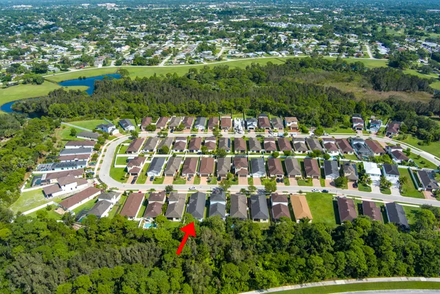 an aerial view of residential houses with outdoor space and trees